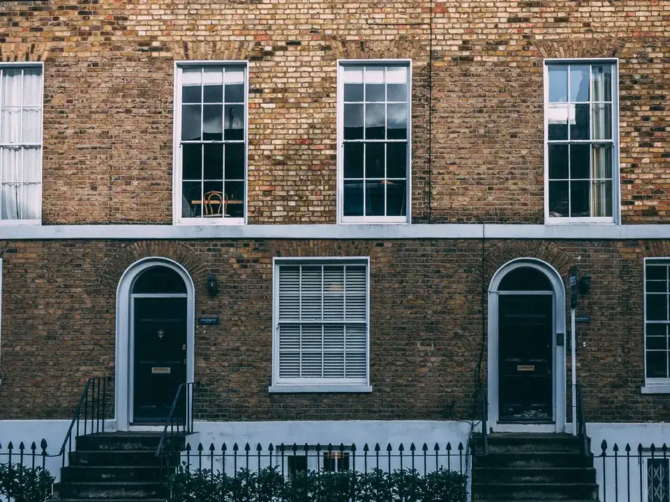 Georgian brick terrace with sash windows, arched fanlight doorways, stone steps and iron railings in London
