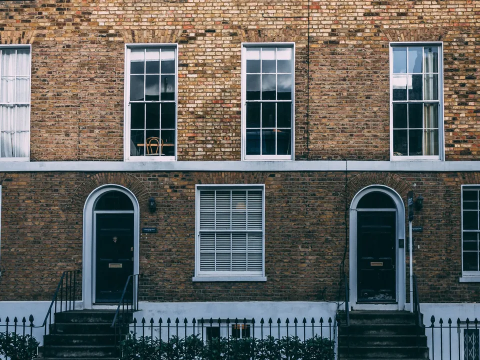 Georgian brick terrace with sash windows, arched fanlight doorways, stone steps and iron railings in London